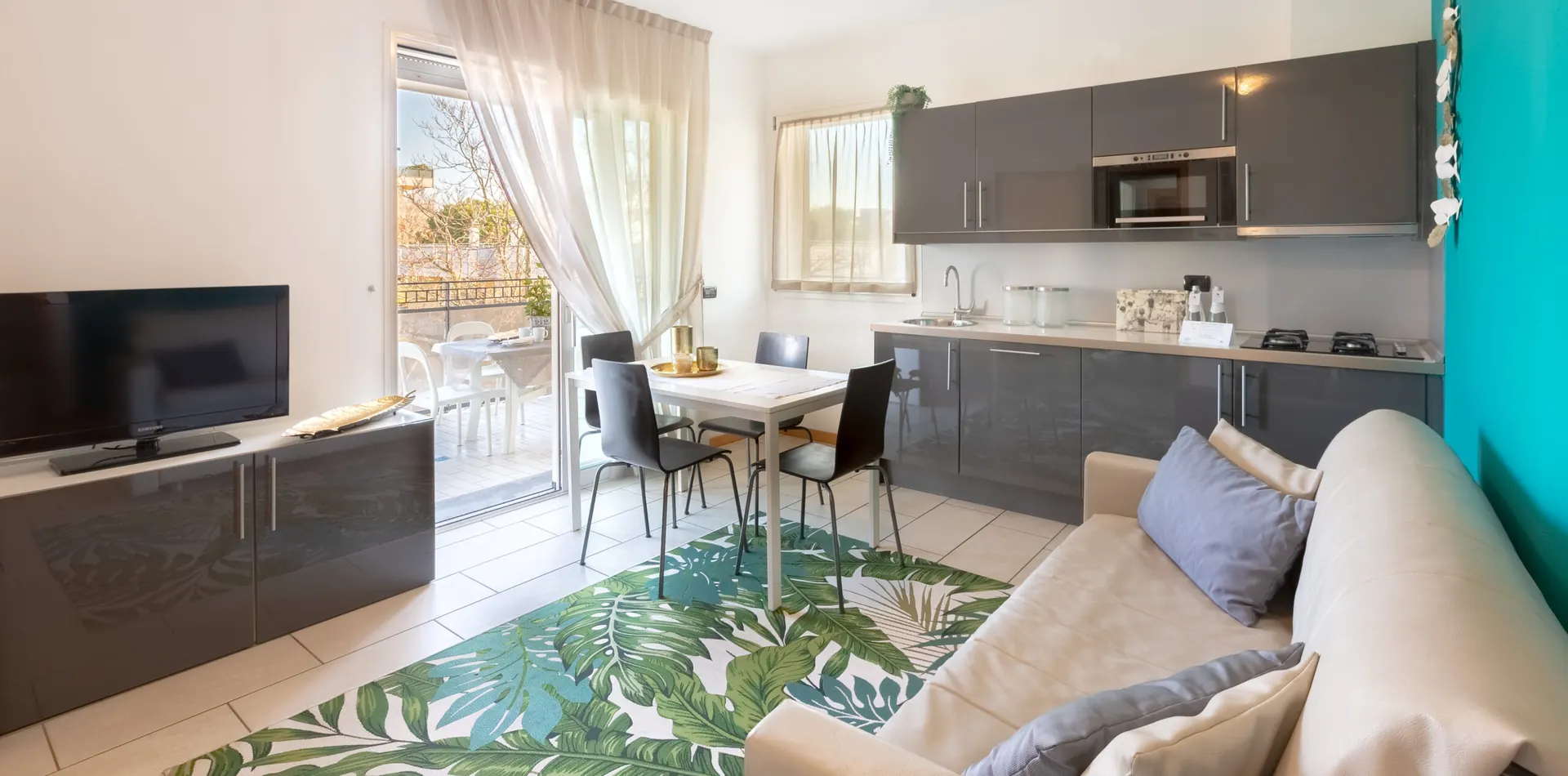 Soggiorno con cucina a vista di un appartamento Dory Suite a Riccione